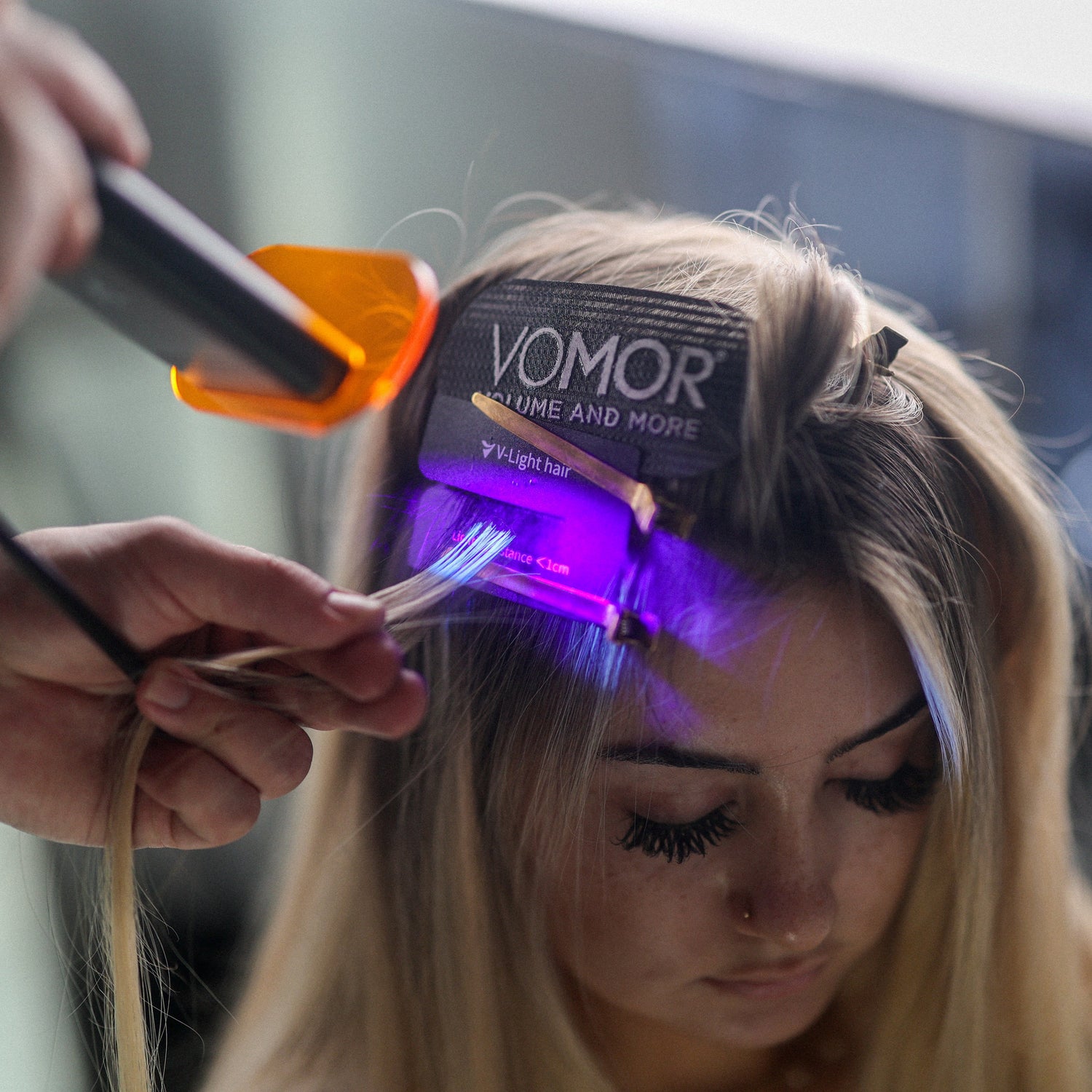 Person getting a hair treatment with a VOMOR device on a blurred background